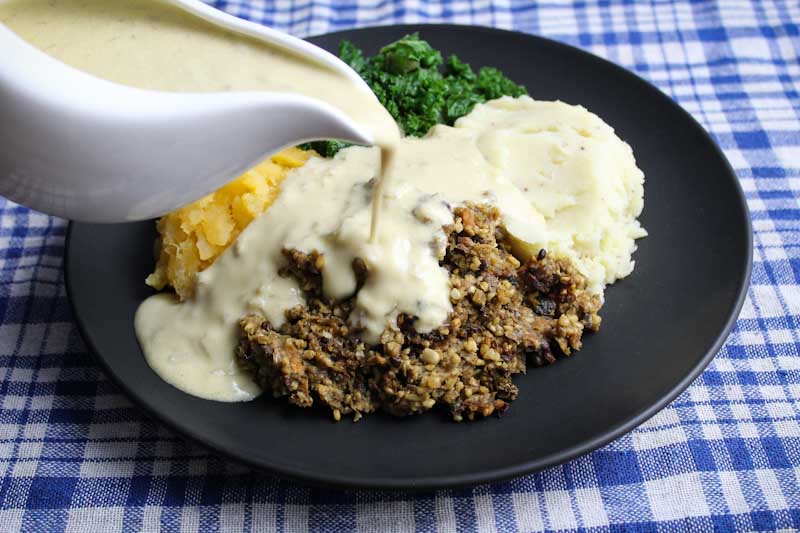 Pouring Whisky Sauce over Vegan Haggis
