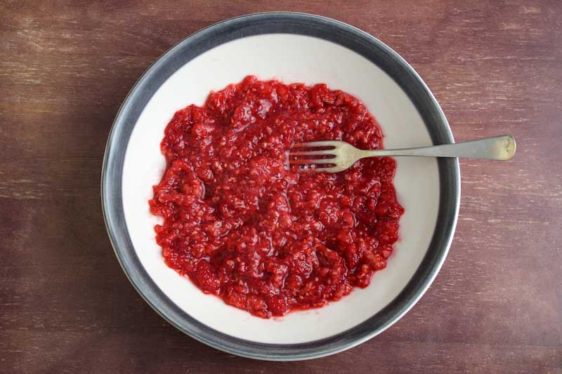 Mashed Raspberries in Bowl with Fork