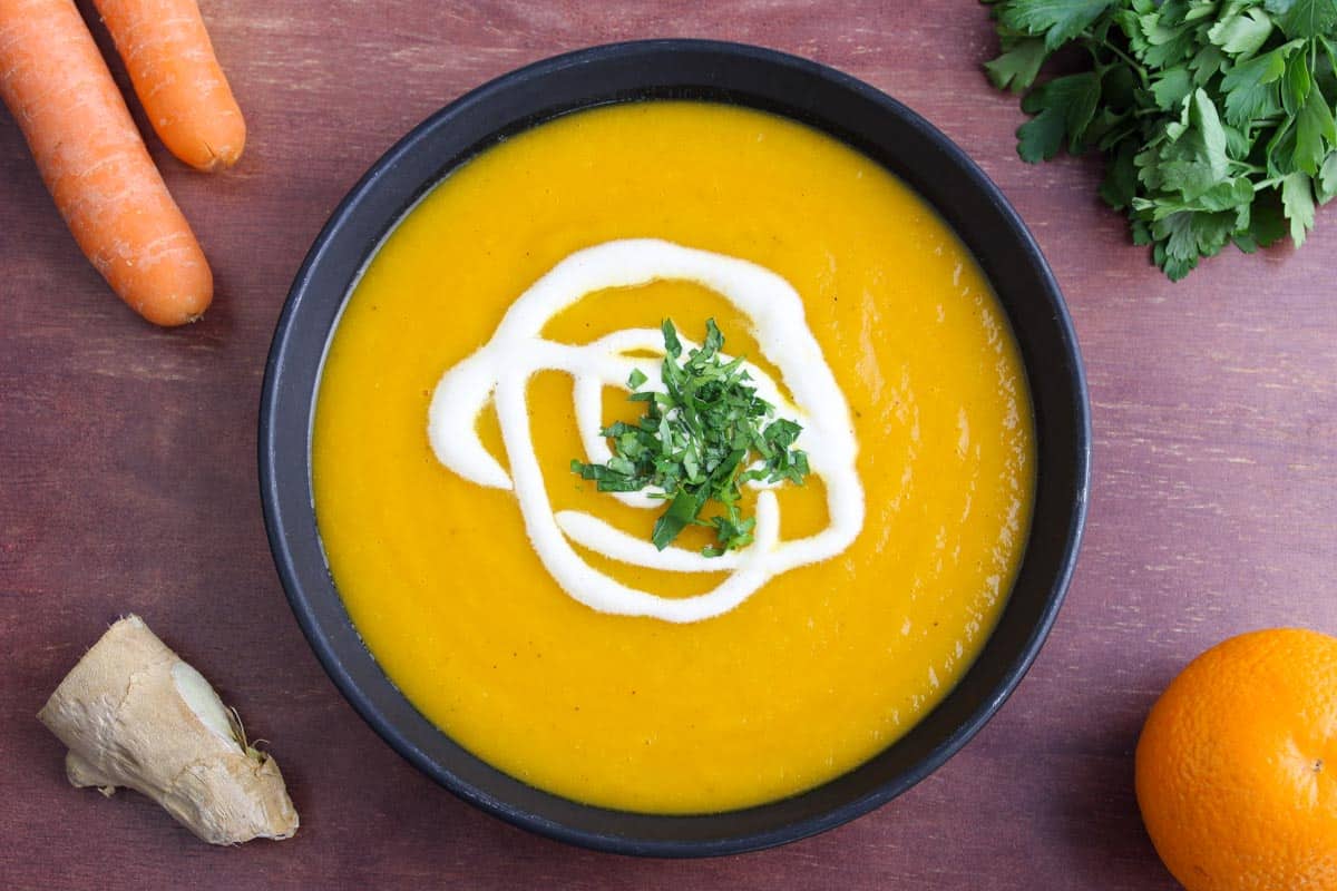 Carrot, Ginger and Orange Soup in Bowl with Ingredients