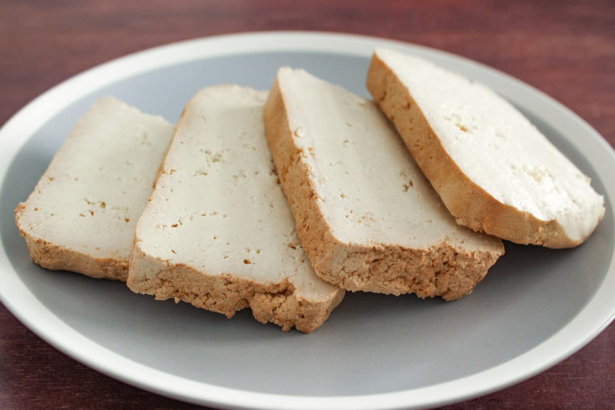 Slices of firm tofu on a plate.