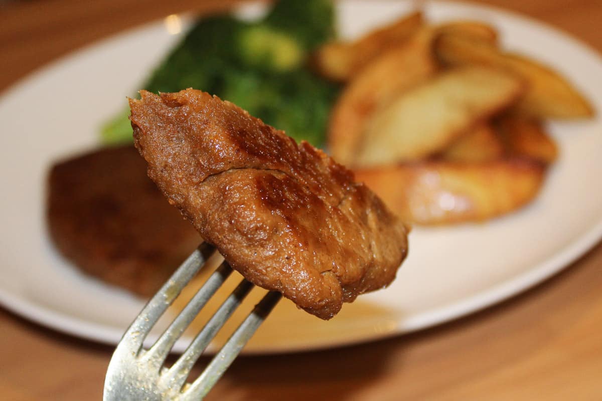 Homemade vegan seitan steak on fork.