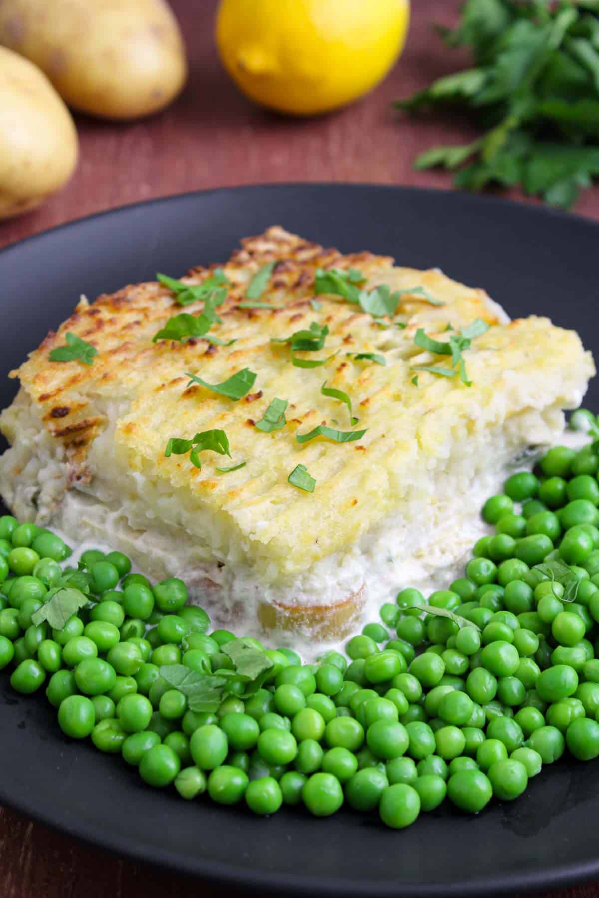 Tofu fish pie on plate with green peas.