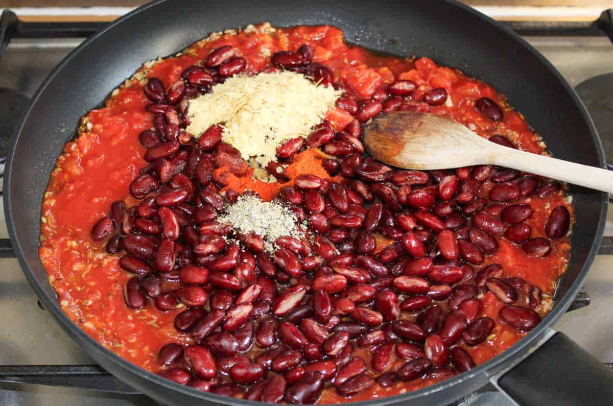 Recipe Process Shot – Adding Kidney Beans and Tomatoes to Pan