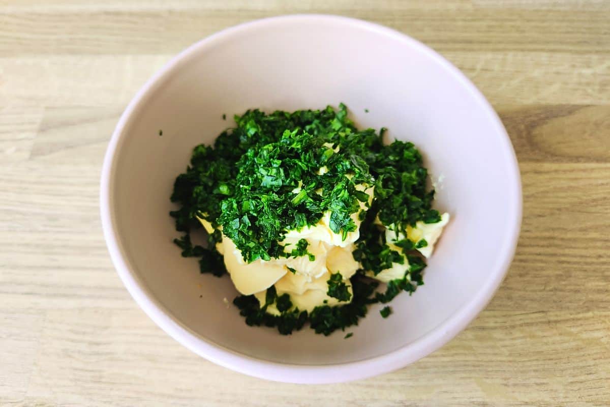 Adding finely chopped wild garlic leaves to bowl with softened butter