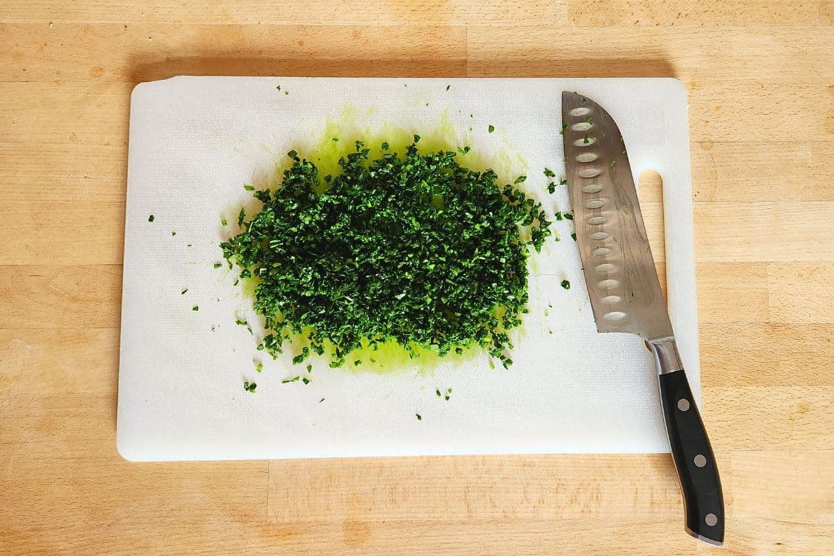 Finely chopped wild garlic leaves on chopping board with knife