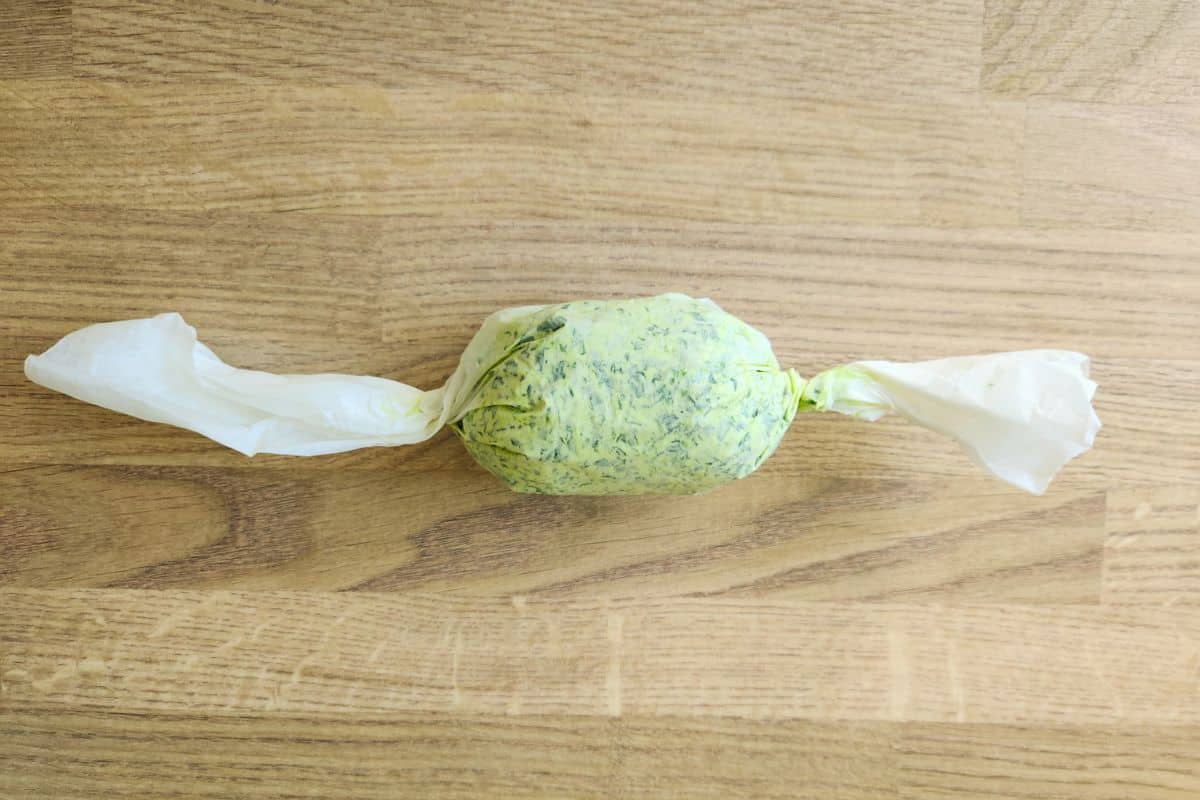 Twisting ends of greaseproof paper to create a tight shape