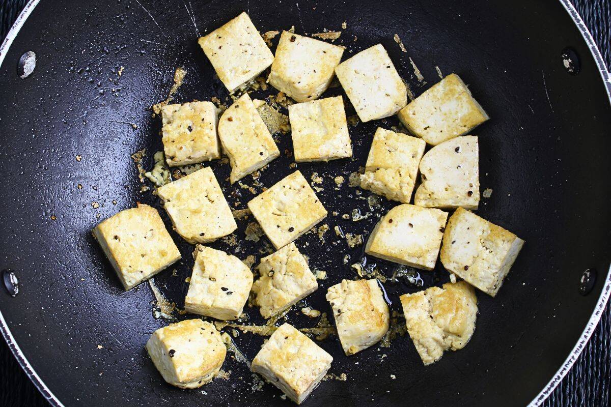 Pieces of extra-firm tofu frying in pan