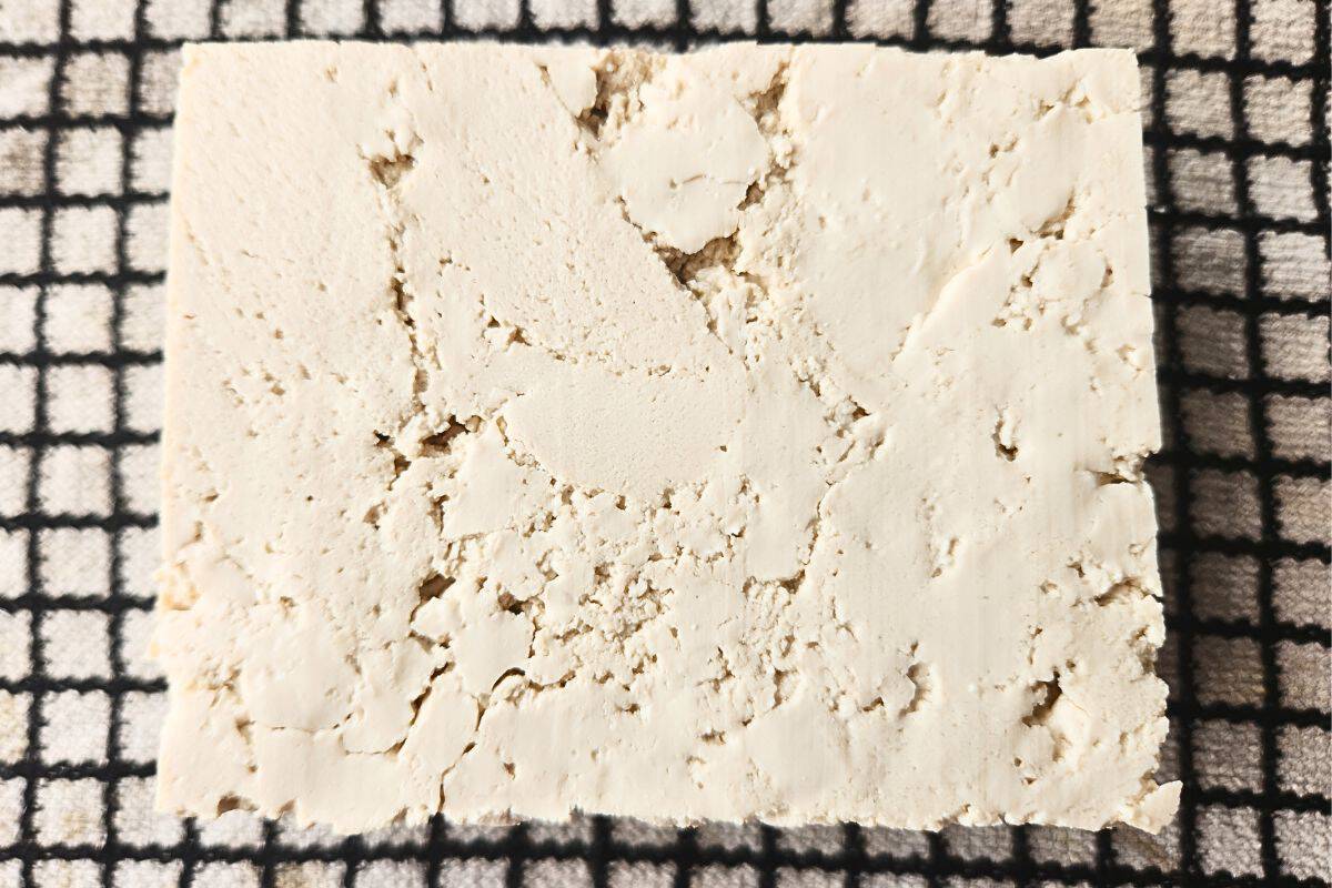 Tofu block on cloth before pressing