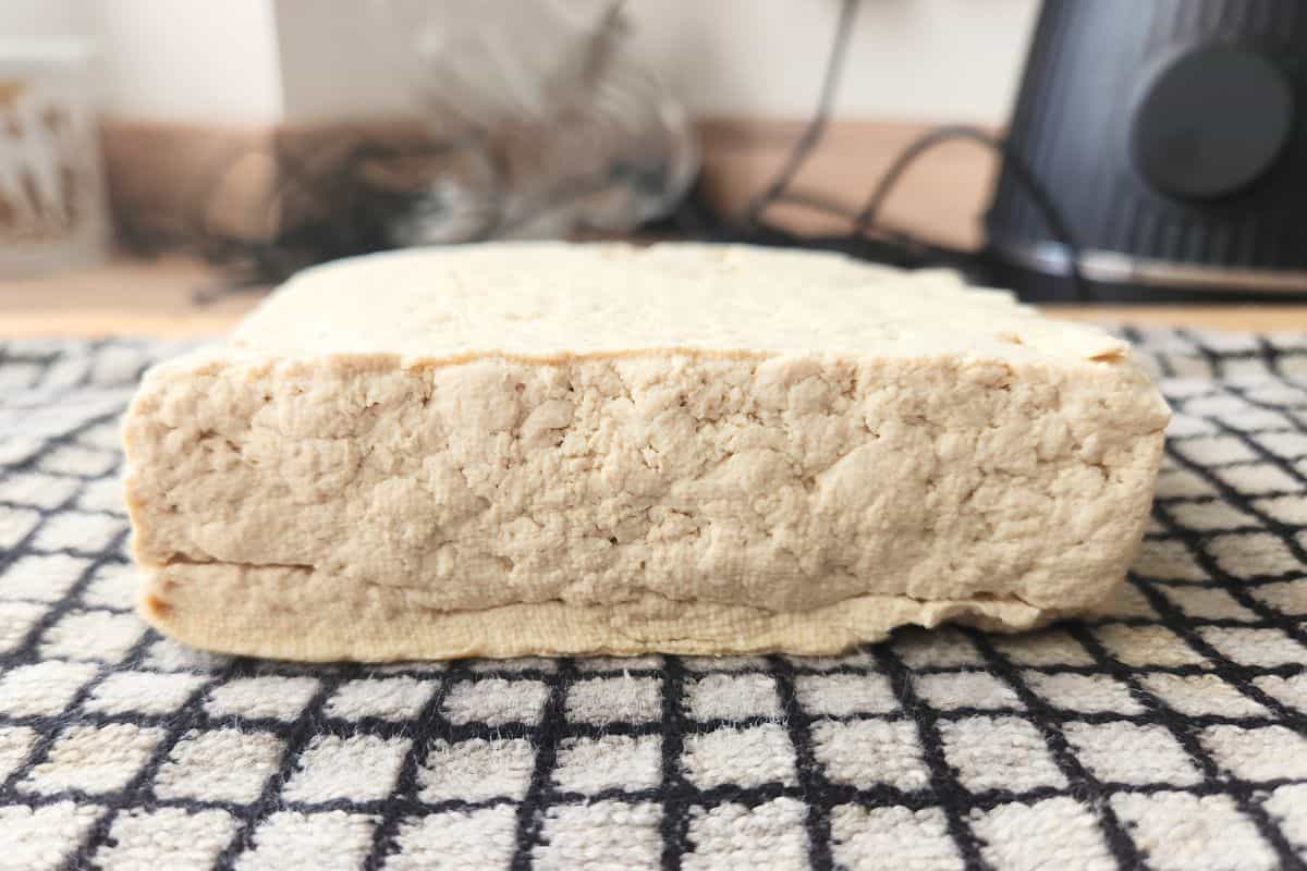 Pressed tofu block on cloth with water removed