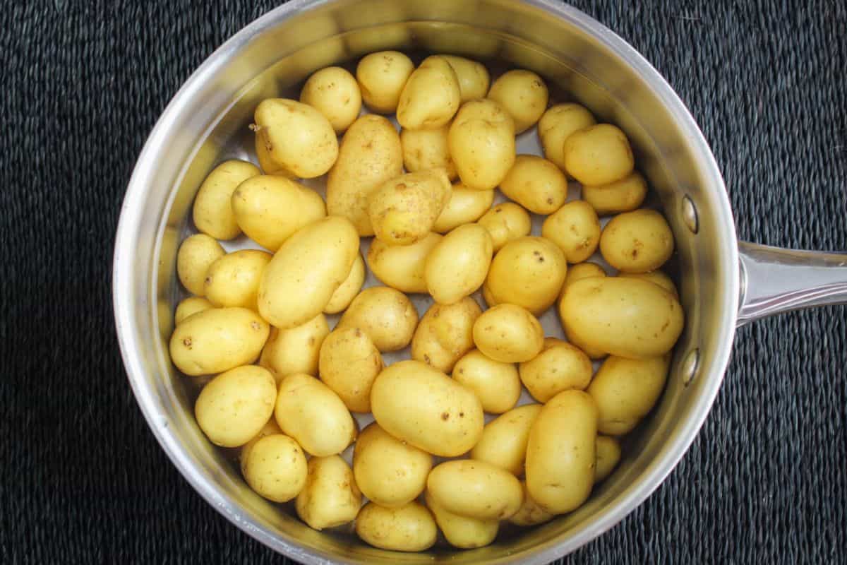 Potatoes in pot covered with salted water