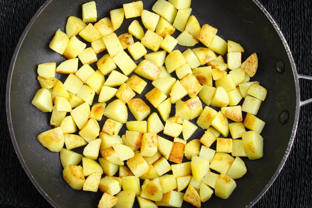 Potatoes frying in oil in pan