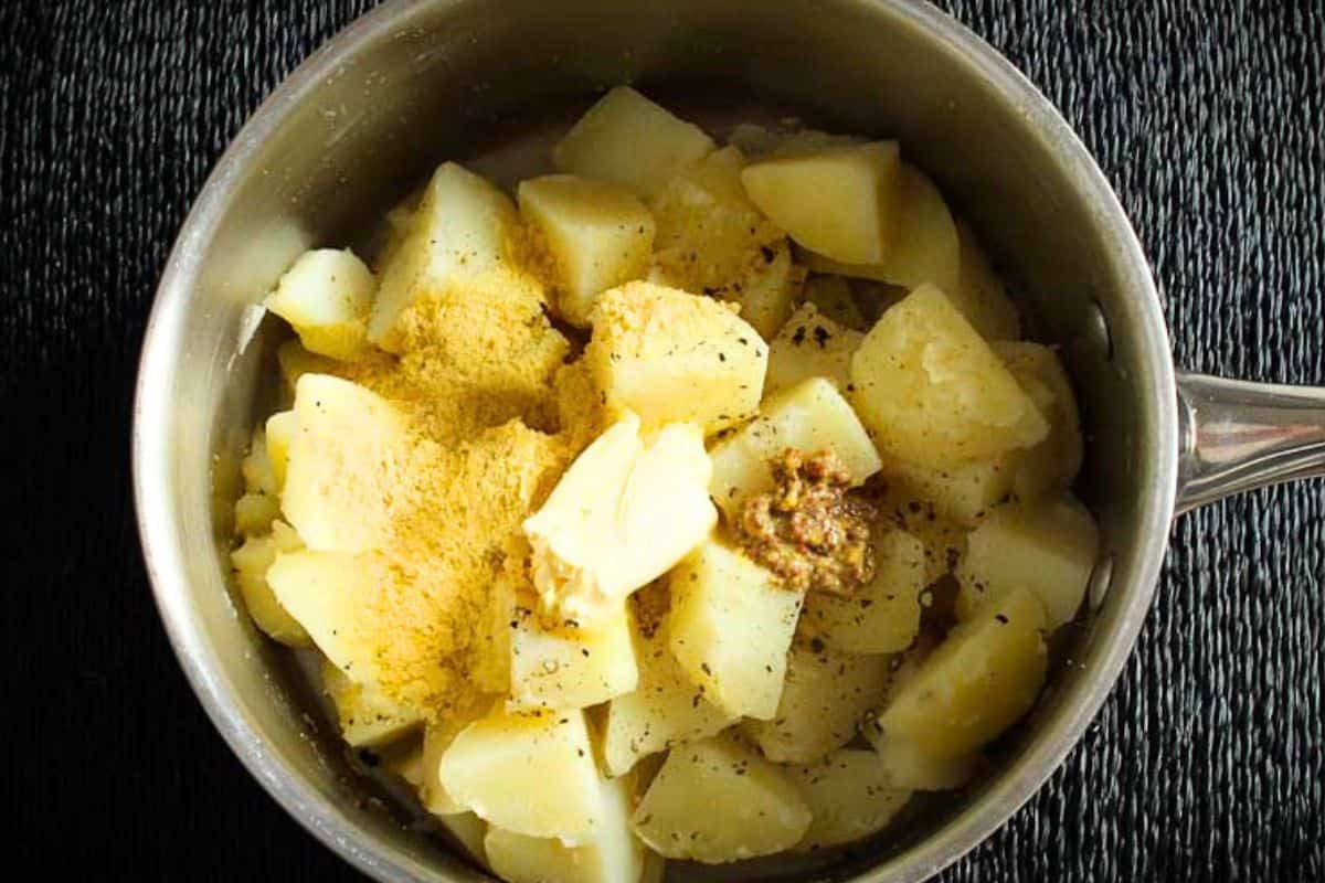Cooked and drained potatoes in pan ready for mashing