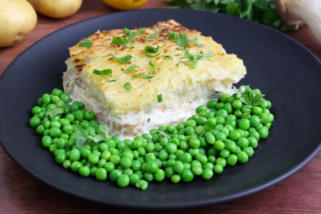 Vegan 'fish' pie on plate with green peas