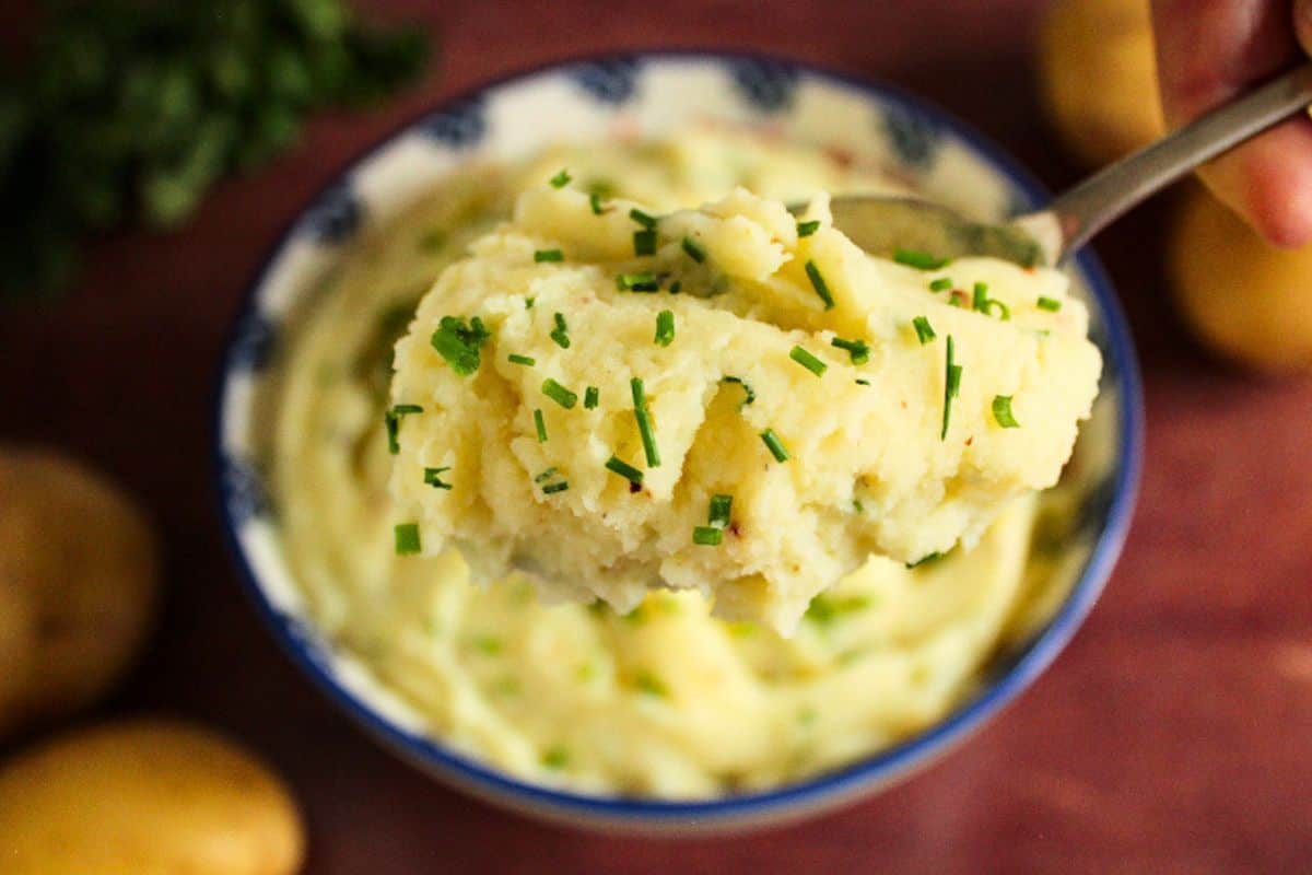 Creamy vegan mashed potatoes on serving spoon
