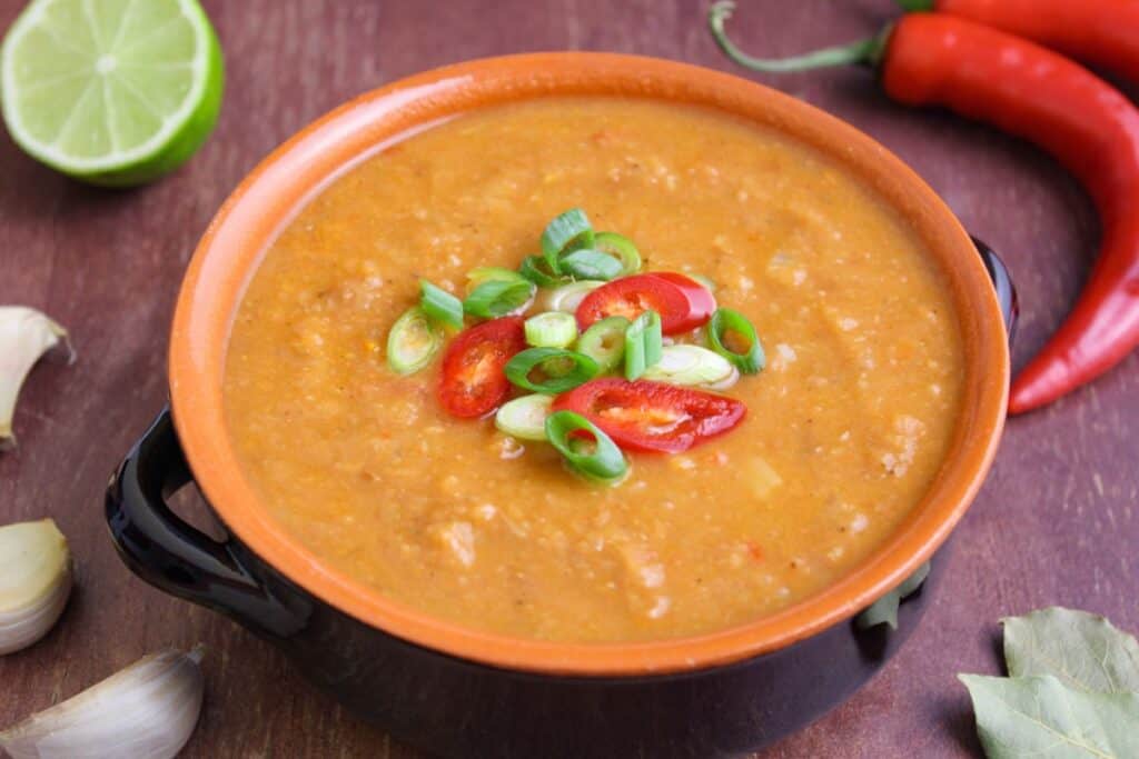 Pinto bean and potato soup in bowl with fresh chilli